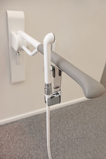 Esimerkki käsisuihkun pidikkeestä, joka on kiinnitetty käsitukeen.