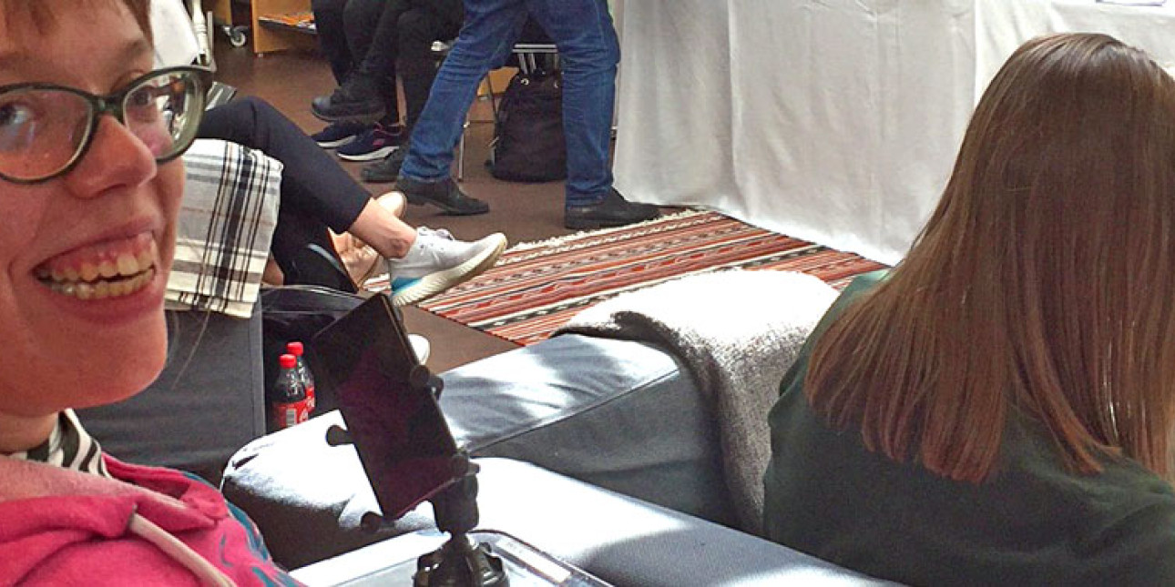 Punapaitainen tyttö hymyilee etualalla. Kuva kevätkokouksesta.