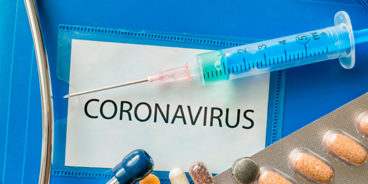 Kyltti jossa lukee CORONAVIRUS ja sen päällä ruiske ja sen vieressä lääkkeitä