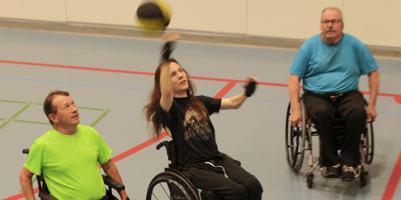 Kolme henkilöä pelaamassa pyörätuolikoripalloa