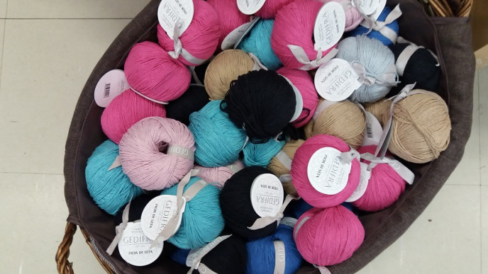 Erivärisiä lankakeriä korissa