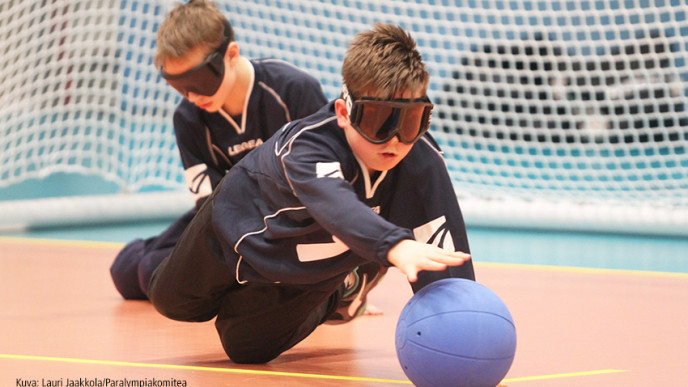 Pojat pelaavat pallopeliä suojalasit päässä.