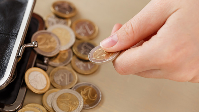 Käsi ottaa euroja rahapussista. Kuvituskuva.