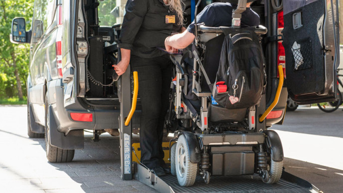 Sähköpyörätuoli nostetaan invataksiin.