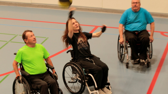Kolme henkilöä pelaamassa pyörätuolikoripalloa