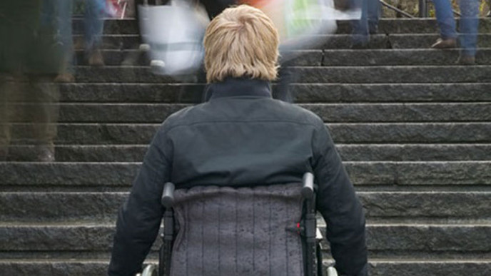 Henkilö pyörätuolissa portaiden juurella
